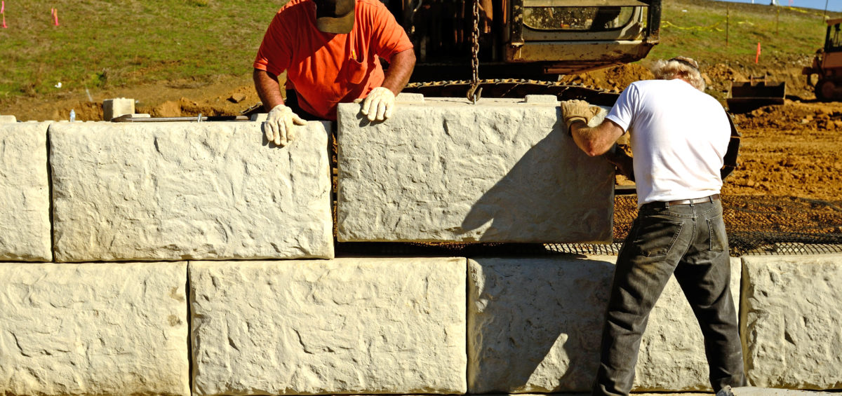 Construction workers assembling a retaining wall